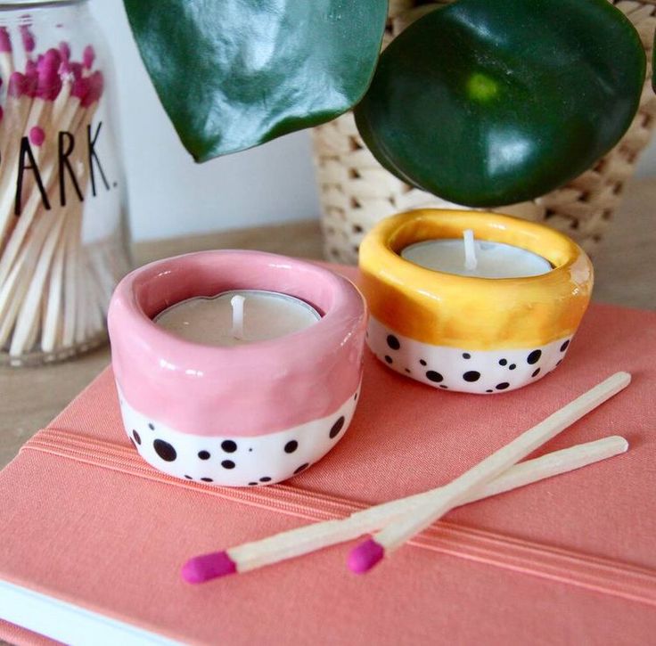 two candles sitting on top of a pink book