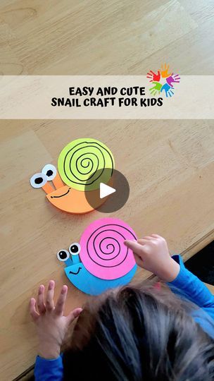 a child is playing with snail craft for kids on the wooden table in front of them