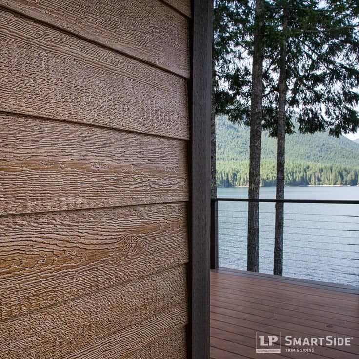 a wooden deck overlooks the water and mountains