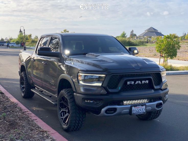 a black ram truck is parked on the side of the road