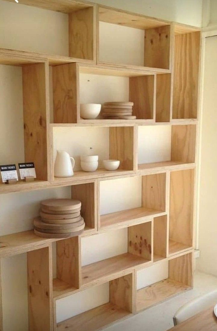 the shelves are made out of wood and have bowls on them, plates in front of them