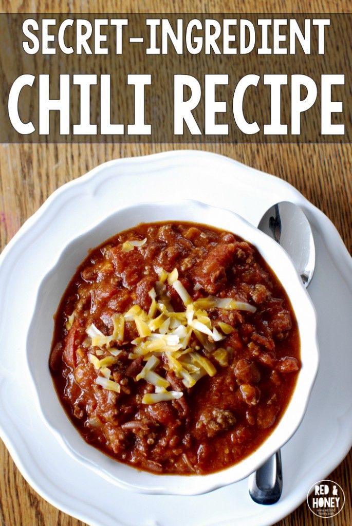 a white bowl filled with chili on top of a wooden table