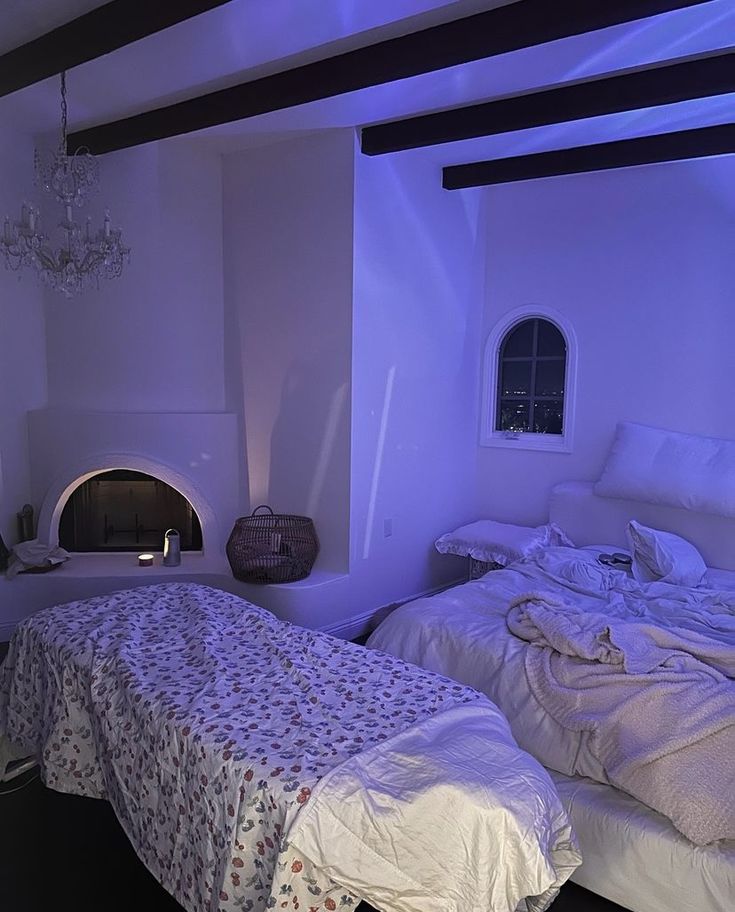 a bed room with two beds and a fireplace in the wall next to each other