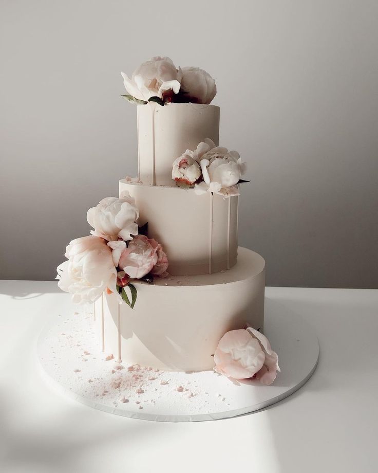 a three tiered cake with flowers on top