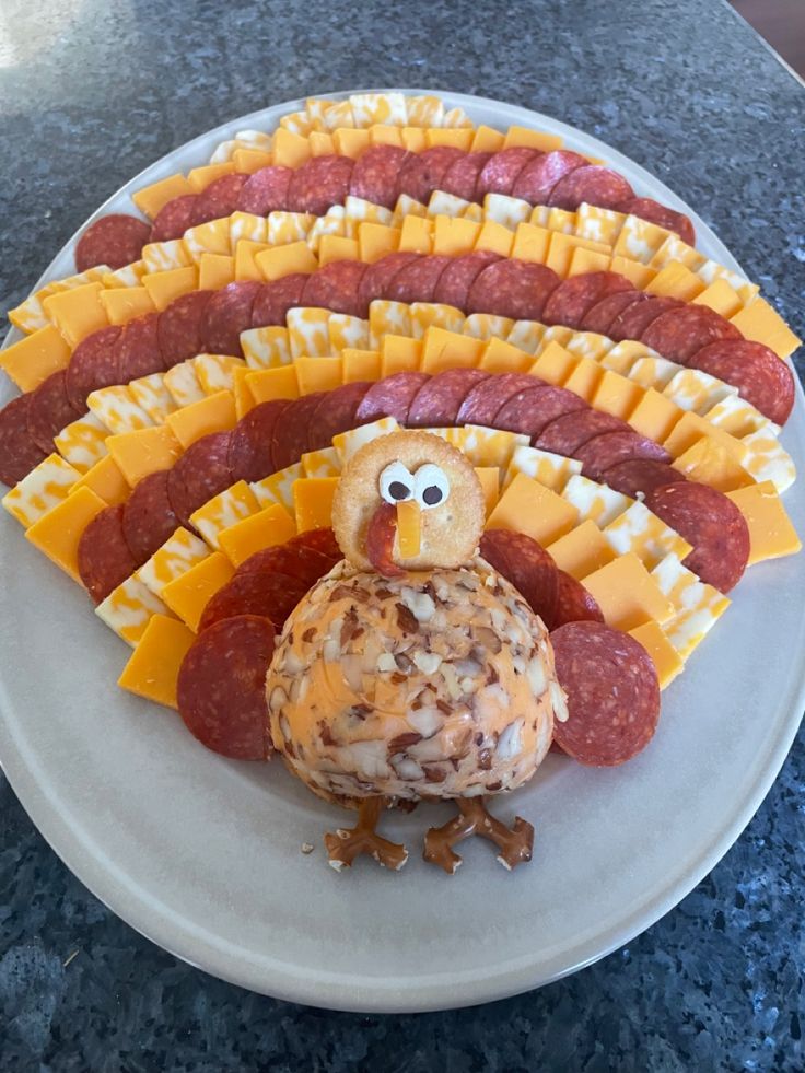 a turkey and cheese platter on a plate with crackers in the shape of sausages