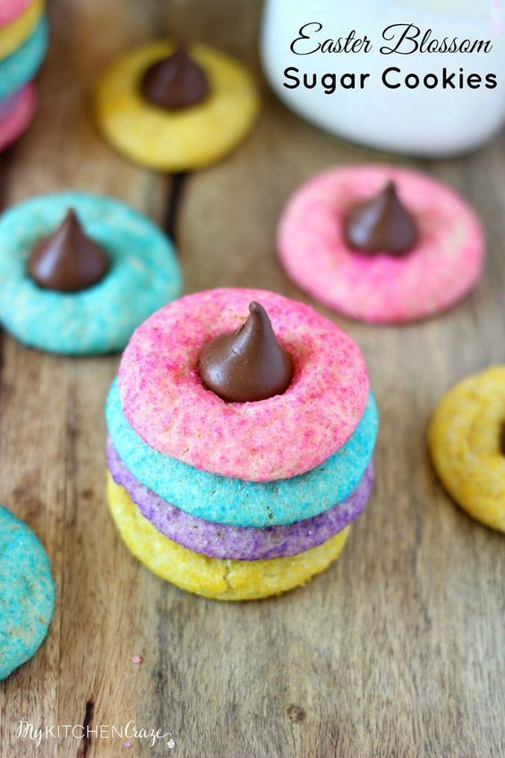 colorful cookies with chocolate frosting and sprinkles on a wooden table top