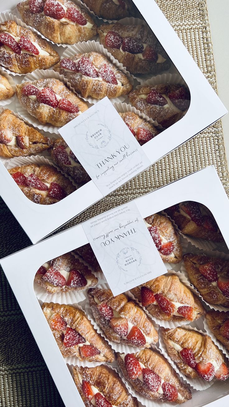 two boxes filled with pastries sitting on top of a table