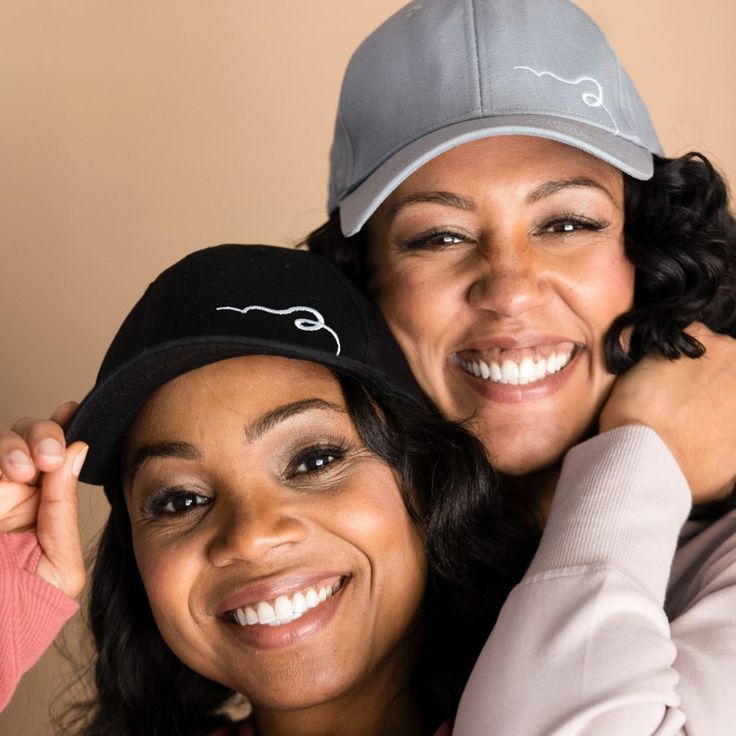 two women are smiling and hugging each other