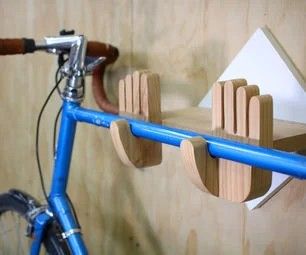 a blue bike is parked in front of a wooden wall with two hooks on it