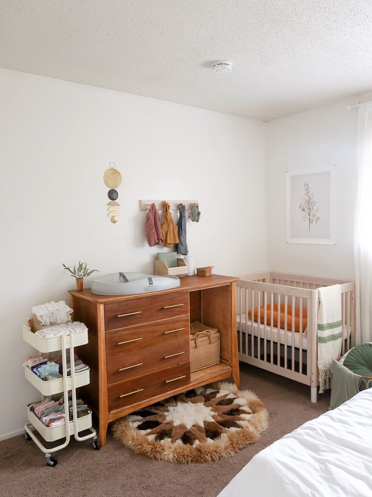 a baby's room with two cribs and a dresser in the corner