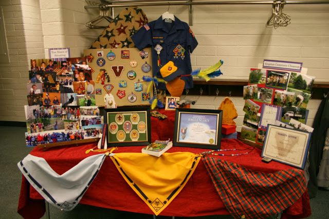 a red table topped with lots of pictures and other items next to a wall covered in magnets