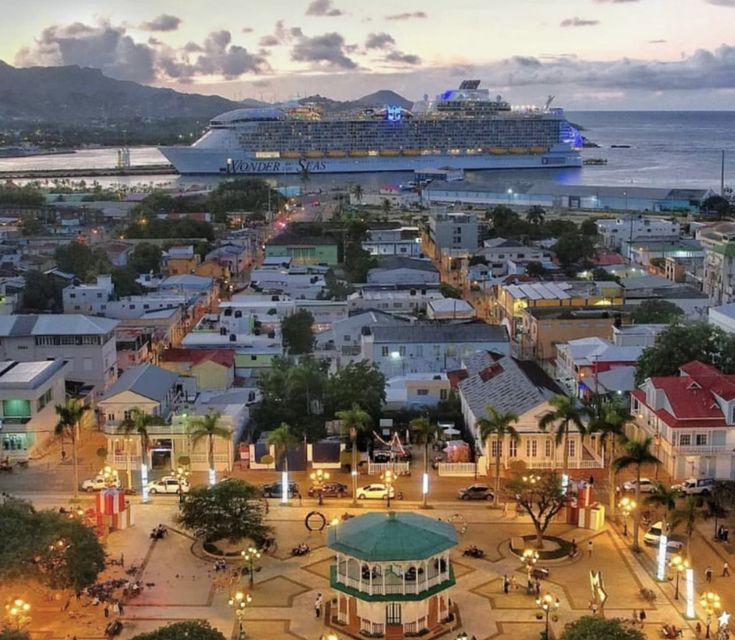 a cruise ship is docked in the harbor at dusk, with other boats and buildings around it