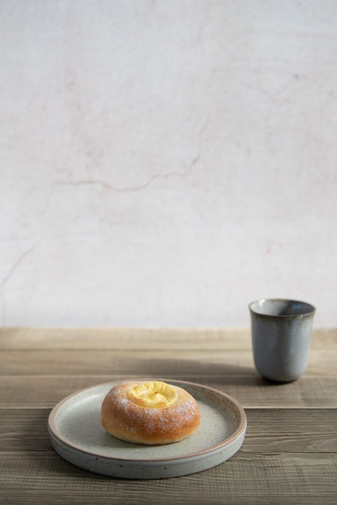 a donut sitting on top of a plate next to a cup