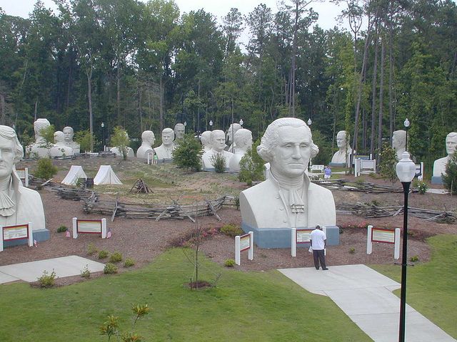 there are many busts in the park and one is standing on his own side