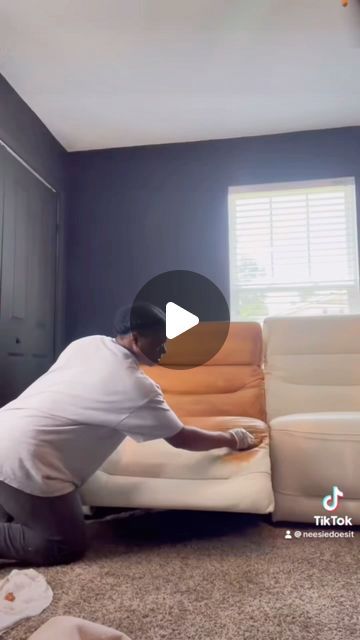 a man laying on the floor in front of a white couch with his feet up