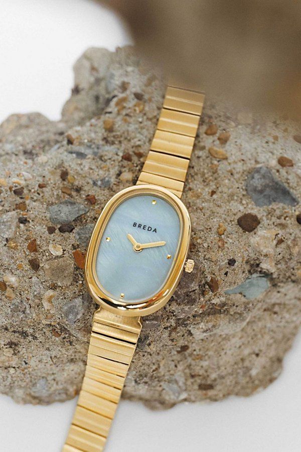 Inspired by days spent in the sun by the water and followed by evenings of indulgence. The Jane carries a delicate 23mm oval case, mother of pearl dial and stainless steel bracelet that fastens with a jewelry clasp. An effortlessly elegant and classic style. Content + Care Stainless Steel Wipe clean with cloth Imported Size + Fit 26mm x 7mm | BREDA Jane Watch in Gold/Blue, Women's at Urban Outfitters Dainty Gold Watch, Vintage Gold Watch, Jewelry Clasps, Steel Bracelet, Stainless Steel Bracelet, Gold Watch, Vintage Gold, Mother Of Pearl, Classic Style