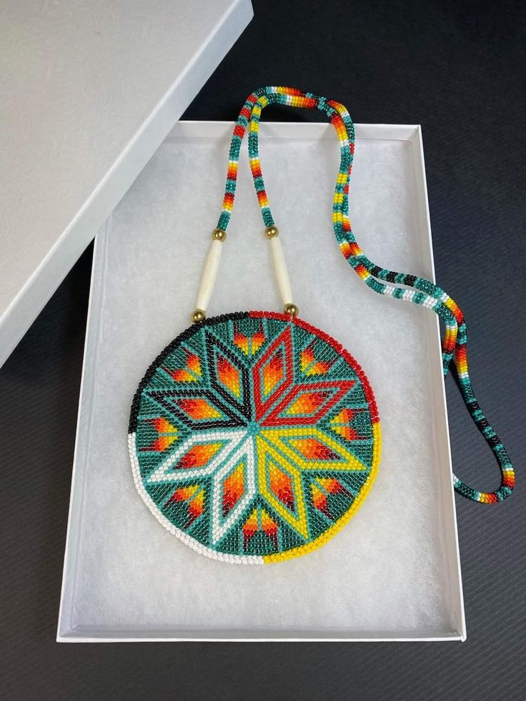 a colorful beaded purse sitting on top of a white box