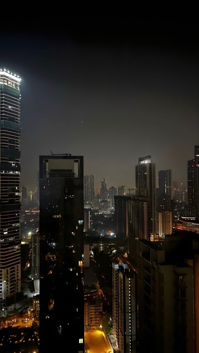 cityscape at night with skyscrapers and lights in the foreground, dark sky