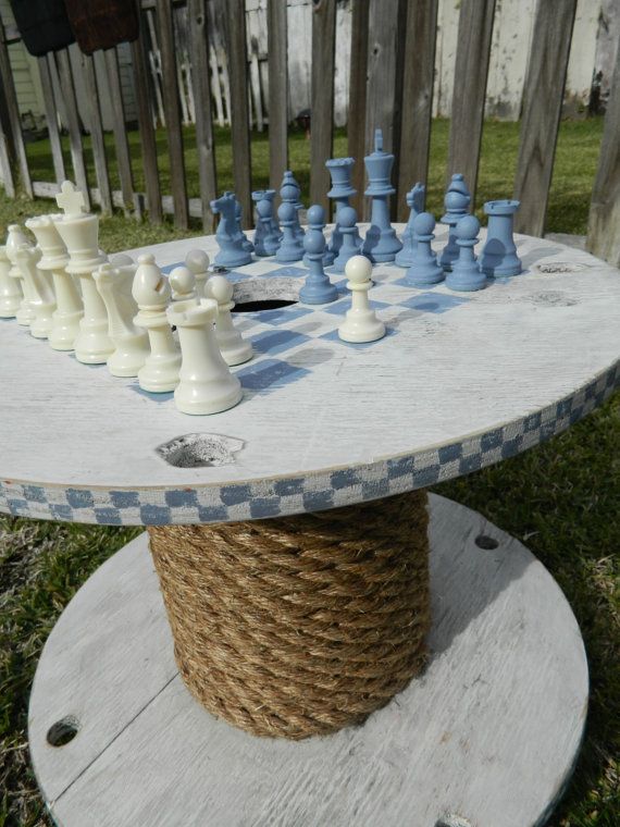 a table made out of rope with chess pieces on it and the words, repurposed milk can table