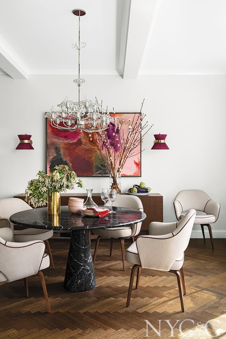 a dining room table with chairs and a chandelier hanging from it's ceiling