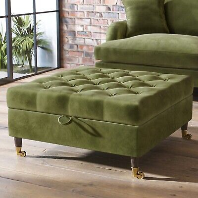 a green chair and footstool sitting on a wooden floor in front of a brick wall