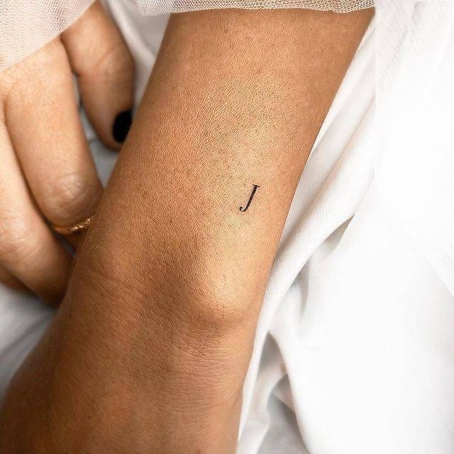 a woman's arm with a small tattoo on the left side of her arm