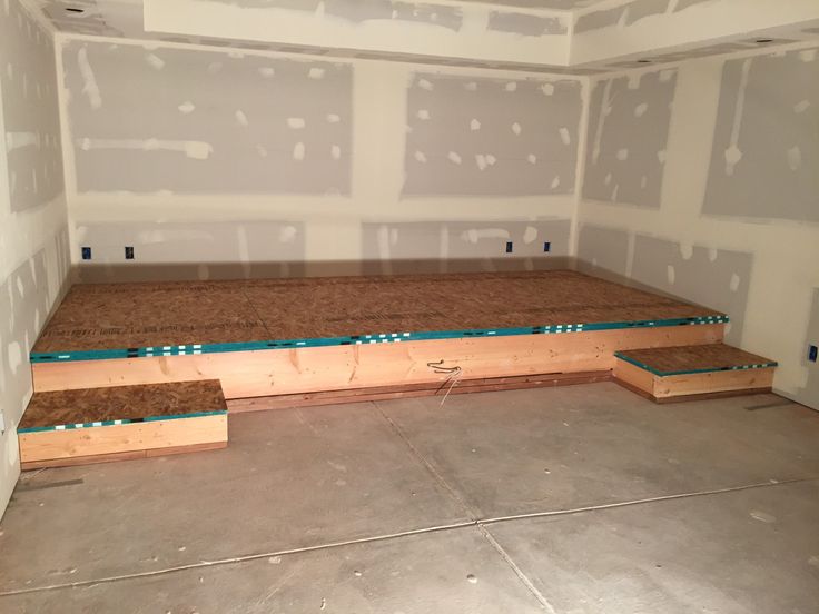 an empty room that is under construction with the floor joists in place for insulation