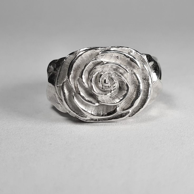 **Please note that we dispatch on Tuesdays unless special delivery express option is paid for** Sterling silver Camellia ring. Original design carved in wax then lost wax cast into solid sterling silver.  Piece weighs approximately 17g.  Shown in a size N, and adjustable to ring sizes I-S.  A significant size adjustment may alter the appearance slightly.  First class post included, with a supplement for special delivery. Sterling Silver Carved Promise Ring, Carved Sterling Silver Rings For Anniversary, Silver Carved Signet Ring Gift, Unique Hand Cast Sterling Silver Signet Ring, Hand Cast Silver Rings For Anniversary, Silver White Bronze Rings As A Gift, Silver White Bronze Rings As Gifts, Silver White Bronze Rings For Gift, Anniversary Sterling Silver Carved Rings