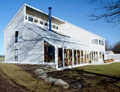 a large white building sitting on top of a lush green field