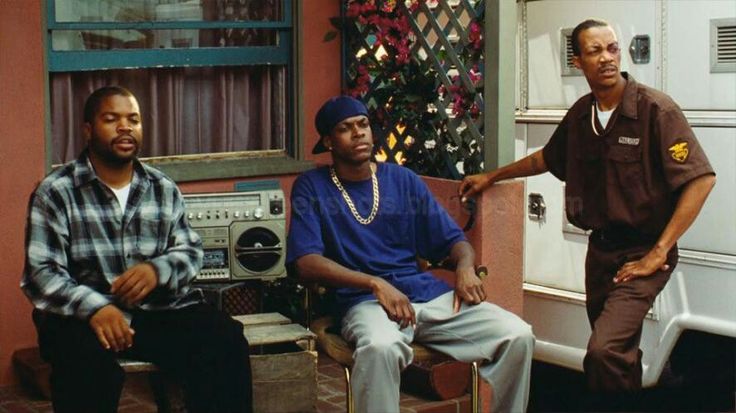 three men are sitting in front of an oven