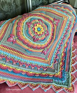 a crocheted granny blanket on top of a bed with pink sheets and pillows