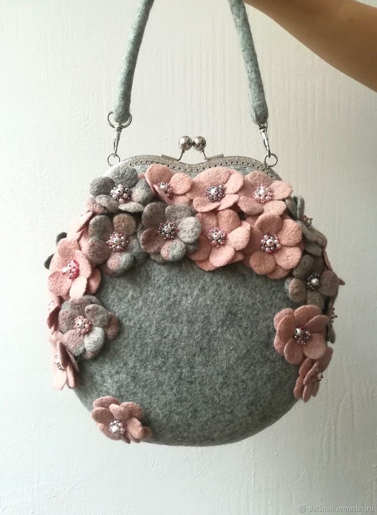 a purse with flowers on it hanging from a wall