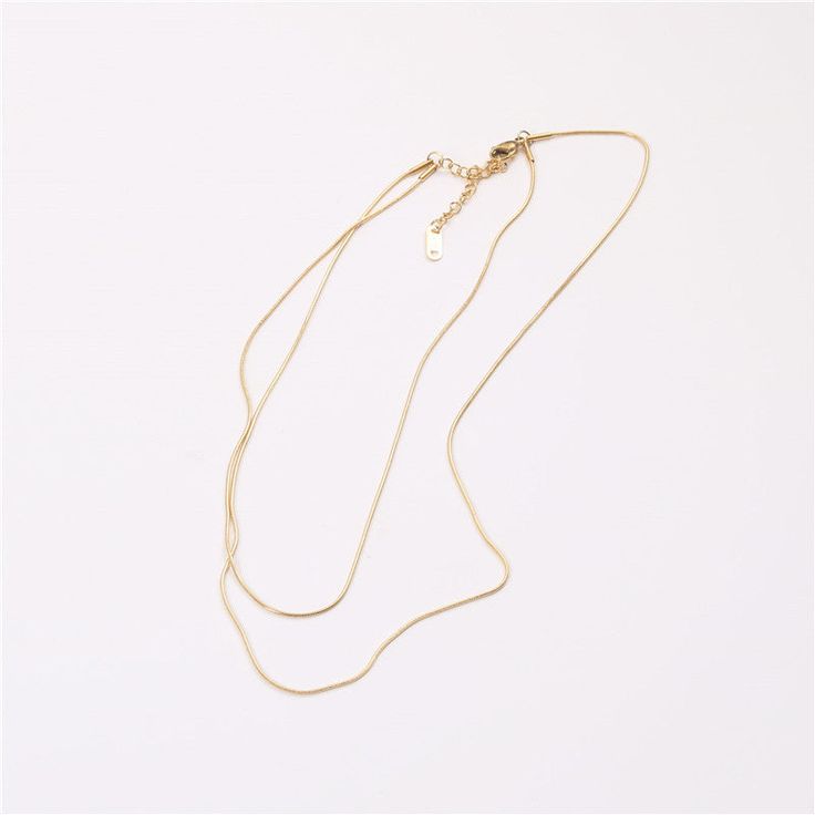 Adorn yourself in chic sophistication with our Double Layered Necklace. Crafted for style and versatility, this piece effortlessly elevates your look. Embrace the modern trend of layered elegance with this exquisite accessory. Elegant Double Chain Necklace For Party, Elegant Multi-strand Delicate Chain Jewelry, Minimalist Multi-strand Metal Layered Necklace, Gold-tone Multi-strand Necklaces For Layering, Trendy Layered Snake Chain Necklace, Minimalist Snake Chain Layered Necklace, Elegant Gold Multi-strand Necklace, Elegant Multi-strand Gold Necklace, Elegant Multi-strand Necklace With Delicate Chain