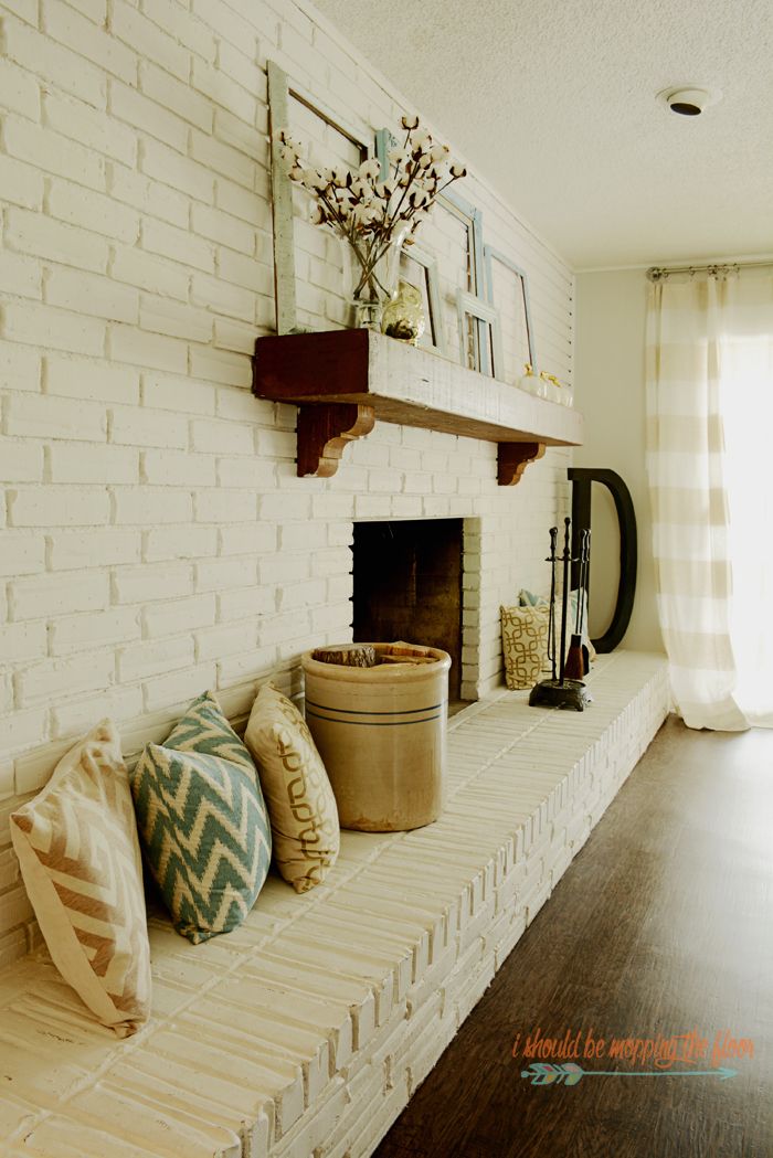 a living room filled with furniture and a fire place under a window next to a wooden floor