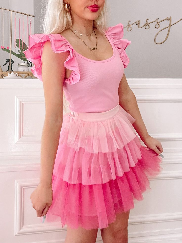 The Shades of Sassy Skirt from Sassy Shortcake is an ombre, tiered, pink tulle, ruffle, skirt. She features an elastic waistband. Lined. Fits true to size, model wearing a size small. Spring Stretch Tiered Skirt, Spring Tiered Stretch Skirt, Stretch Tulle Bottoms With Ruffles, Pink Tiered Bottoms With Layered Hem, Spring Tiered Tulle Skirt Bottoms, Spring Tiered Tulle Bottoms, Spring Tiered Tulle Skirt, Pink Flirty Ruffled Skirt, Flirty Pink Ruffled Skirt