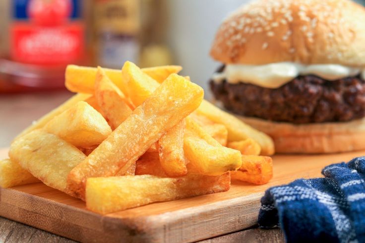 a hamburger and french fries on a cutting board