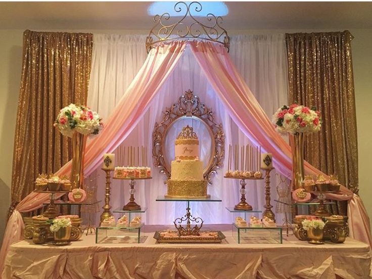 a table topped with a cake covered in pink and white frosting next to a mirror