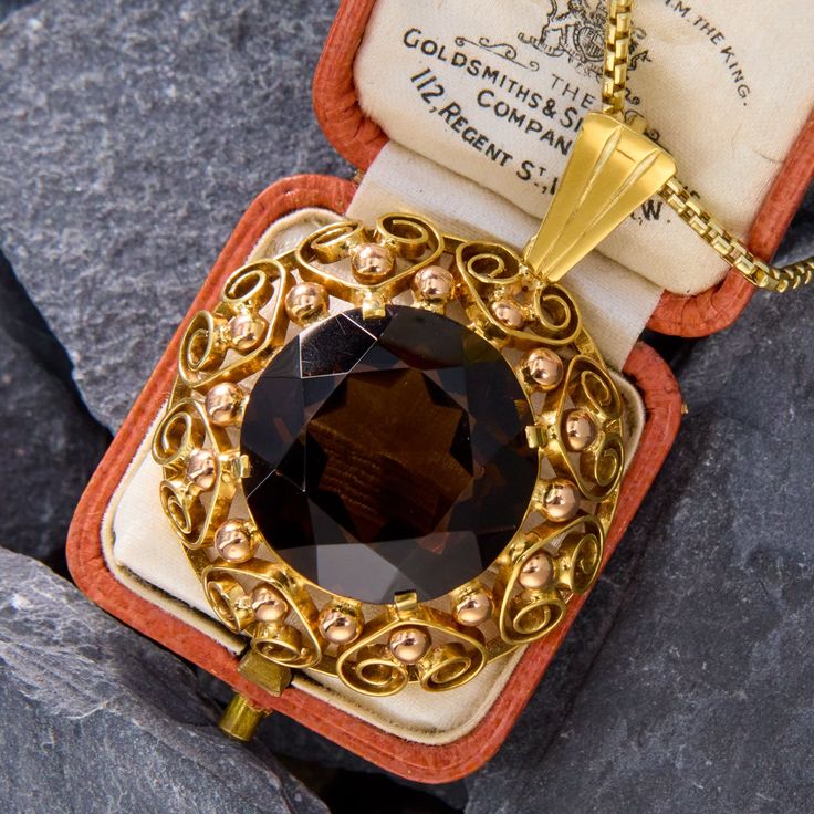 This bold pendant made in Vienna, Austria, holds an 18 carat round cut smoky quartz at its center. The frame is decorated with scrolling details and rose gold beadwork. The pendant is crafted in 14k yellow and rose gold, and the 18 inch rounded box chain it hangs from is also 14k yellow gold. Luxury Collectible Bronze Jewelry, Victorian Pendant Jewelry For Formal Occasions, Victorian 14k Gold Evening Jewelry, Elegant Bronze Necklace With Intricate Design, Victorian 14k Gold Jewelry For Evening, Elegant Bronze Necklaces With Intricate Design, Fine Jewelry In 14k Gold, Brown, Elegant Bronze 14k Gold Jewelry, Fine Jewelry In 14k Gold With Brown Color