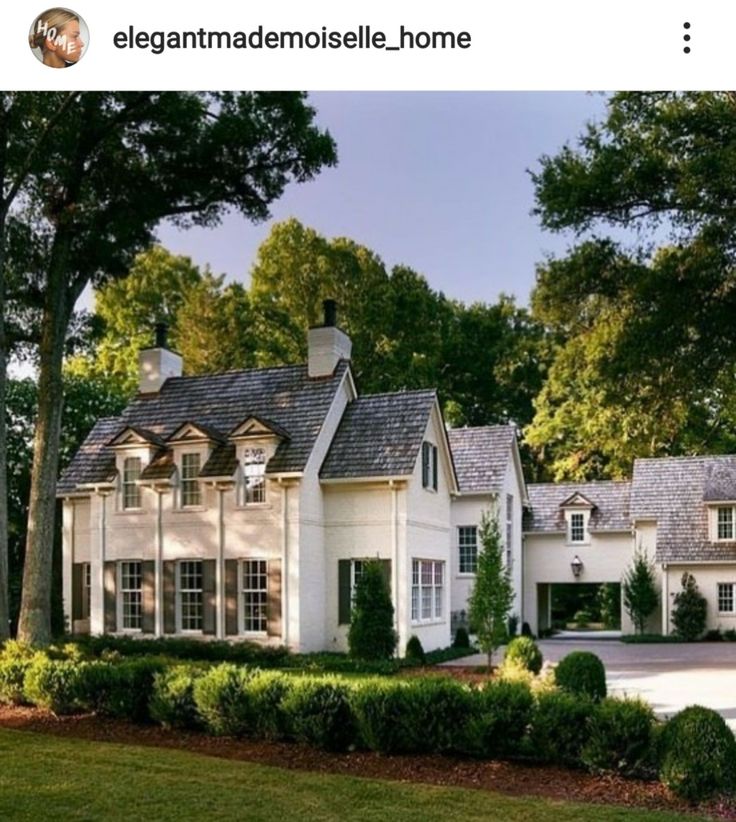 a large white house surrounded by trees and bushes