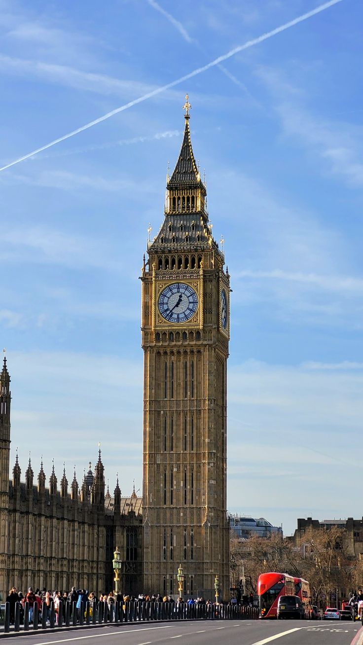 the big ben clock tower towering over the city of london with people standing around it