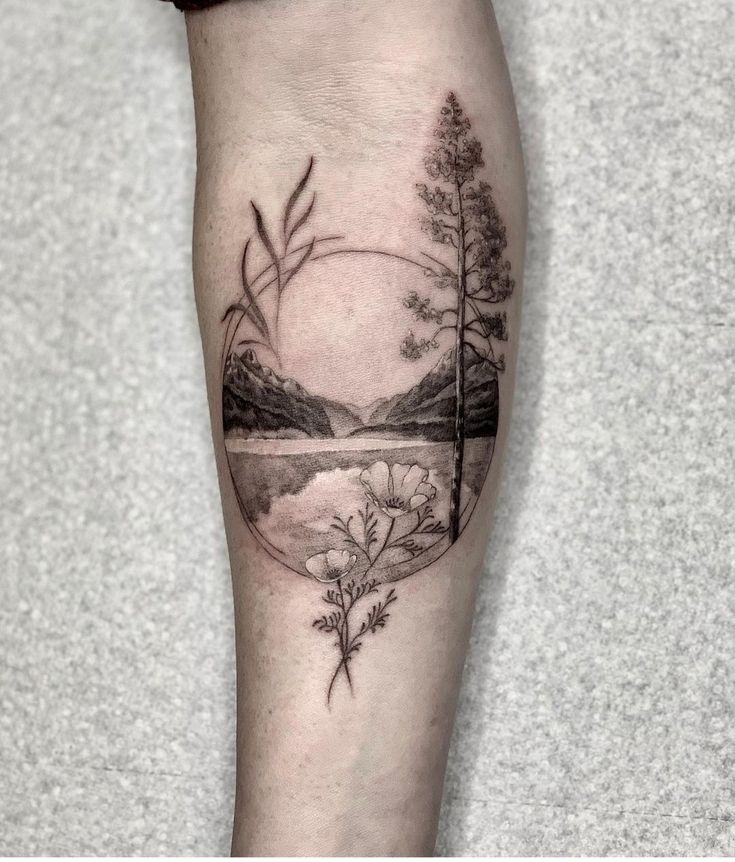 a black and white tattoo on the leg of a person with trees in the background