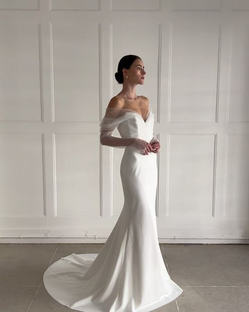 a woman in a white wedding dress posing for the camera with her hands on her hips