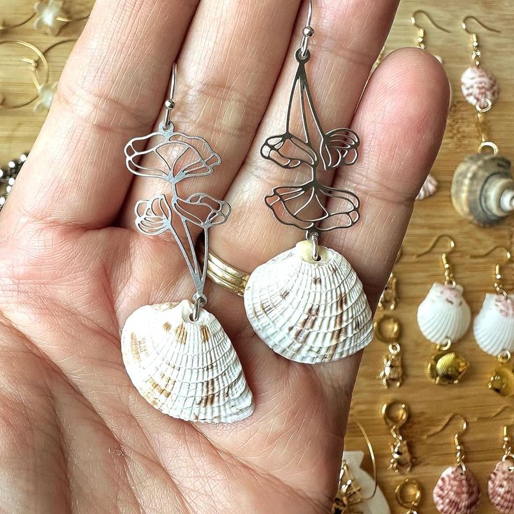 two seashells are being held in the palm of someone's hand