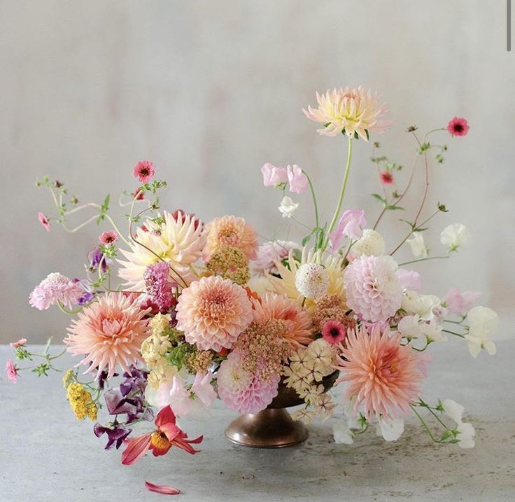 a vase filled with lots of different colored flowers