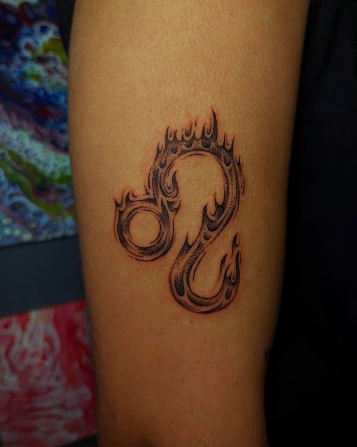 a tattoo on the arm of a woman with an omen symbol in black ink