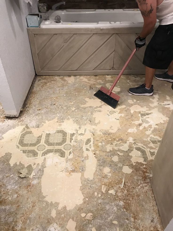 a man with a mop is cleaning the floor in a bathroom that needs to be remodeled