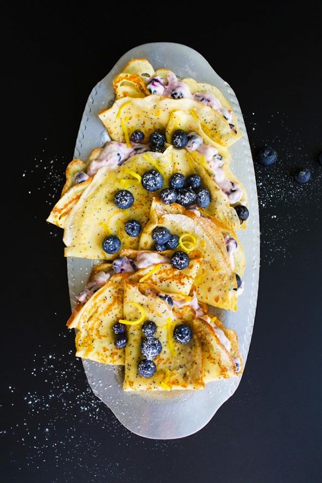 blueberry crepes are arranged on a plate