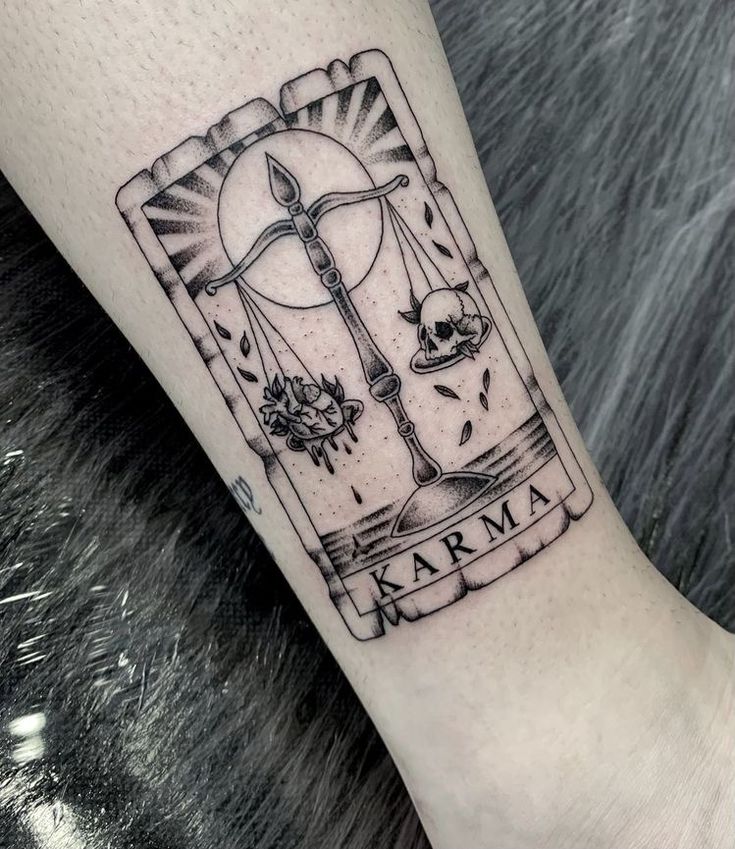 a black and white tattoo on the leg of a woman's arm with an image of a cross