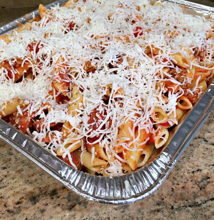 a casserole dish filled with pasta and cheese on top of a granite counter