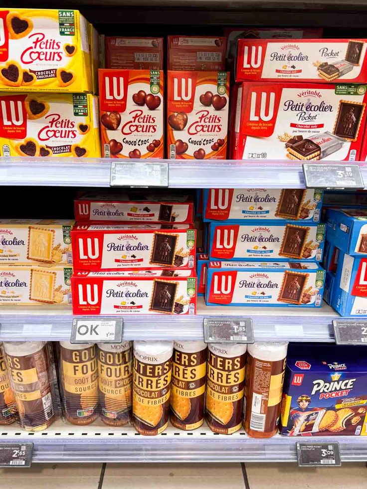 shelves in a store filled with lots of different types of snacks and desserts on display